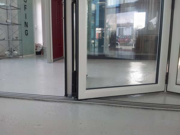NEW PVCU - AlUMINIUM HYBRID Bi Folding door. Close up photo of Flush floor track